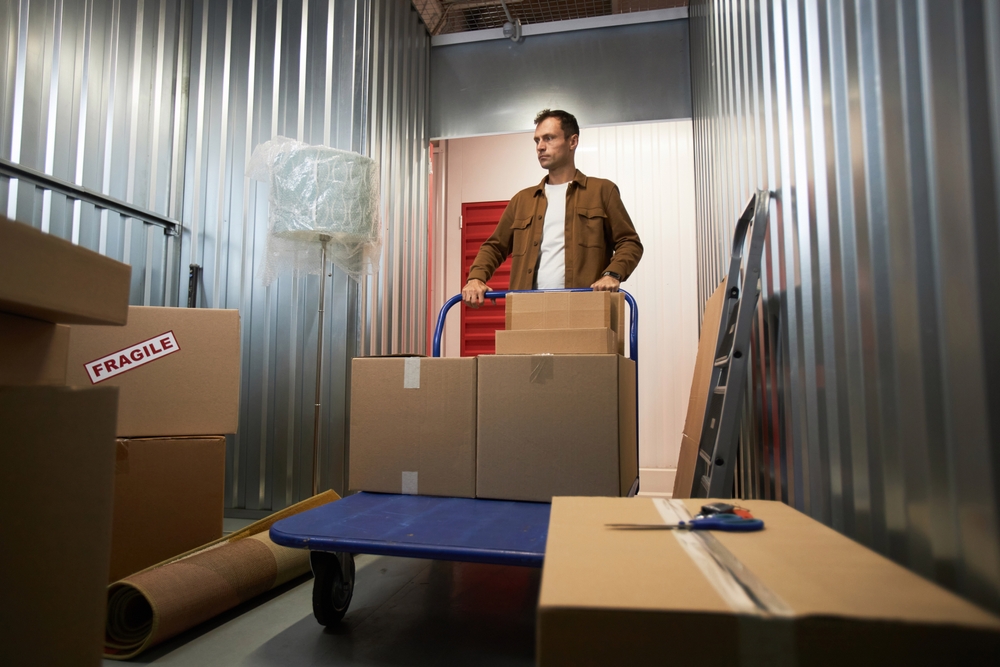 Man,Pushing,Cart,Inside,Storage,Unit