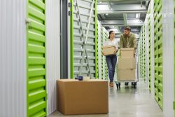 Full,Length,Portrait,Of,Young,Couple,Holding,Cardboard,Boxes,Walking