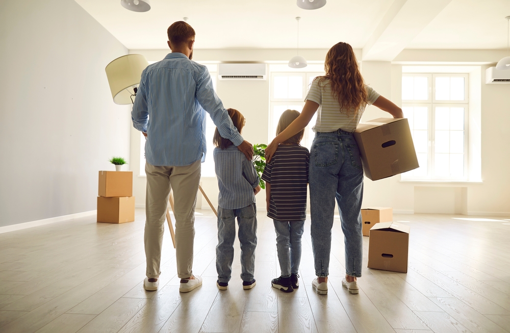 Happy,Couple,With,Children,Standing,Together,In,Their,Own,New